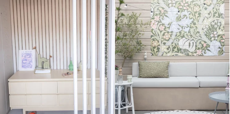 Cupboard with art print frame and small vases with flowers. Garden sofa with green cushion and art print on the wall.