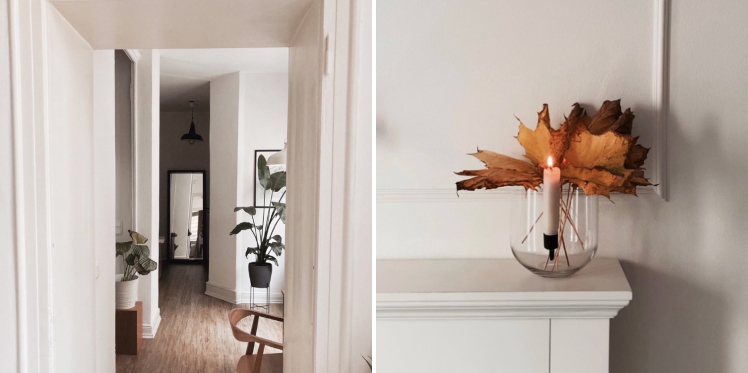 Open door, house plants, wooden chair. Enlighted candle on fireplace with orange leaves behind. 